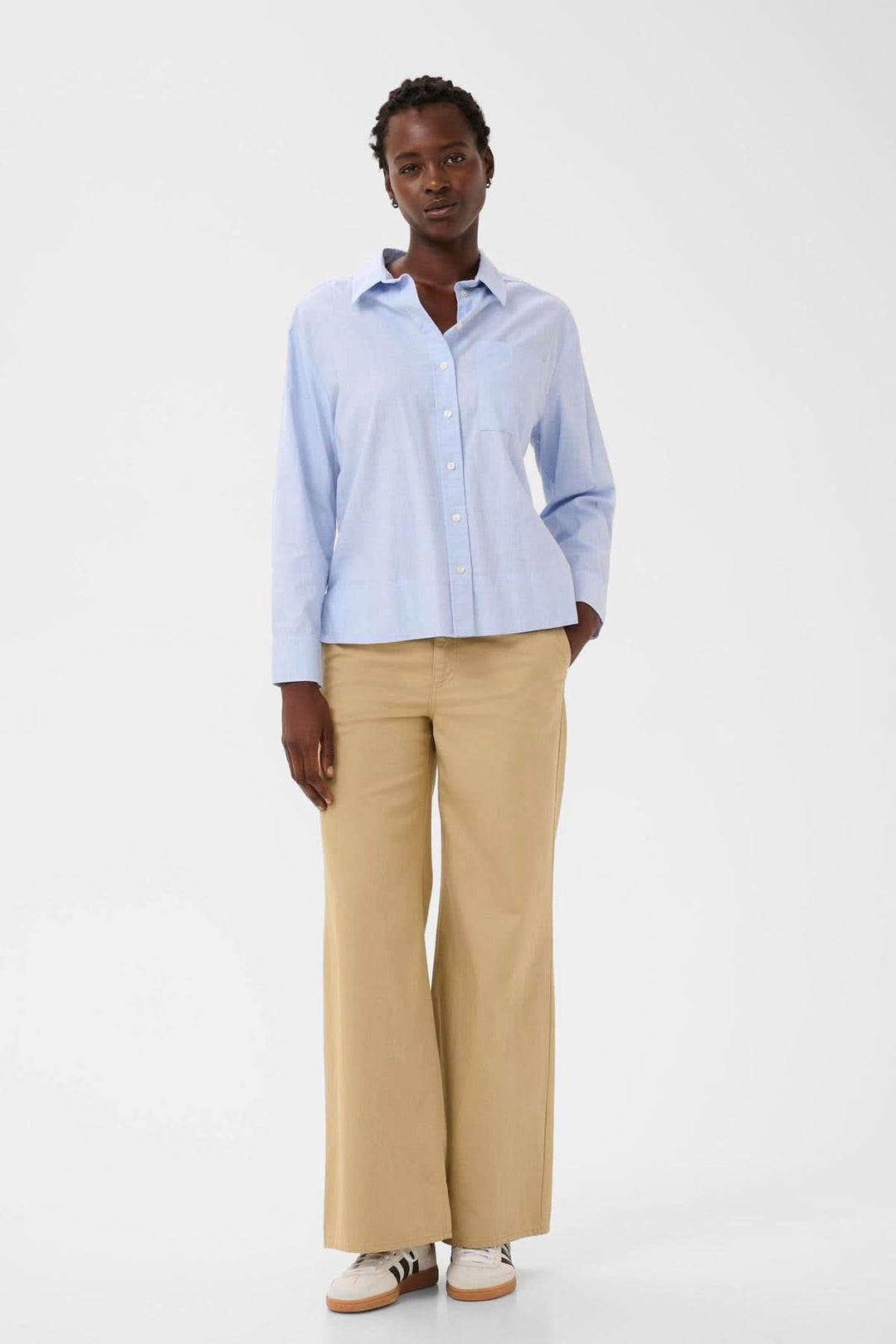 Chemise classique en popeline Nenee portée par une femme, offrant une allure structurée idéale pour le bureau ou des looks décontractés.