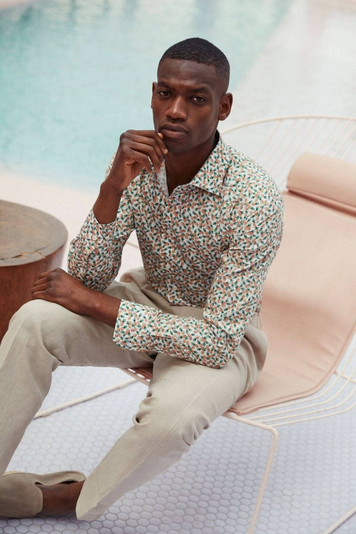 Chemise en coton et TENCEL™ imprimé ananas, élégant et confortable, portée par un homme assis à côté d&