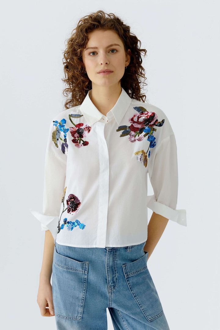 Chemise coupe moderne avec broderies florales, élégance et modernité, col structuré, idéale pour looks soignés ou décontractés.