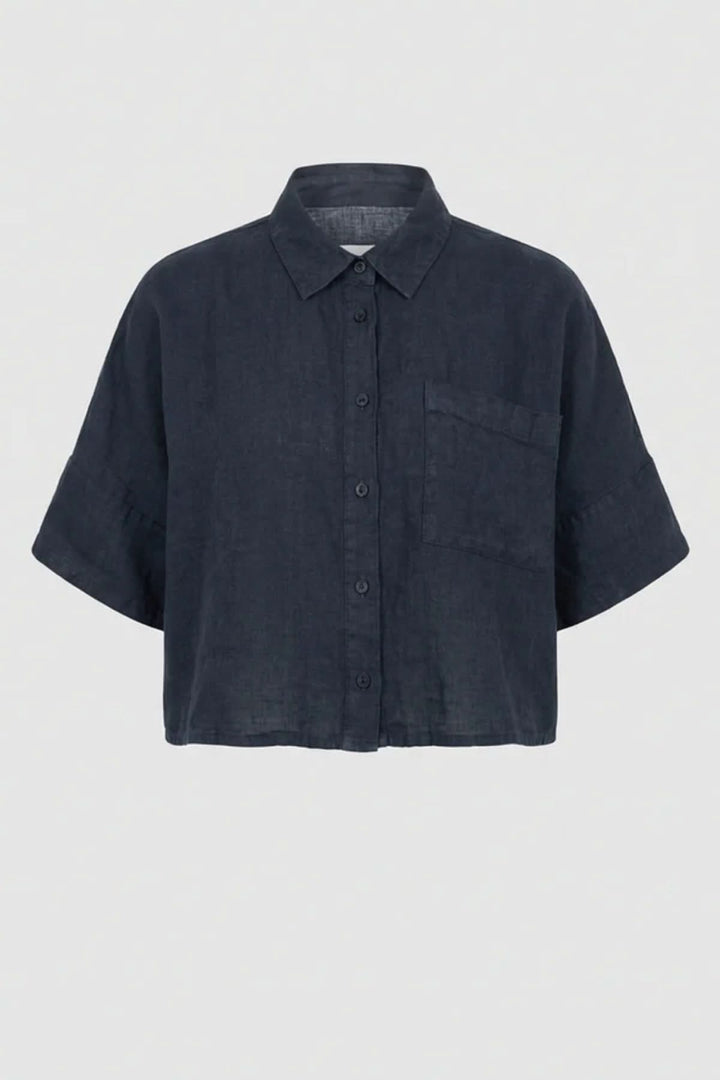 Chemise courte en lin à coupe ample avec col classique et poche plaquée, idéale pour un look moderne et confortable.