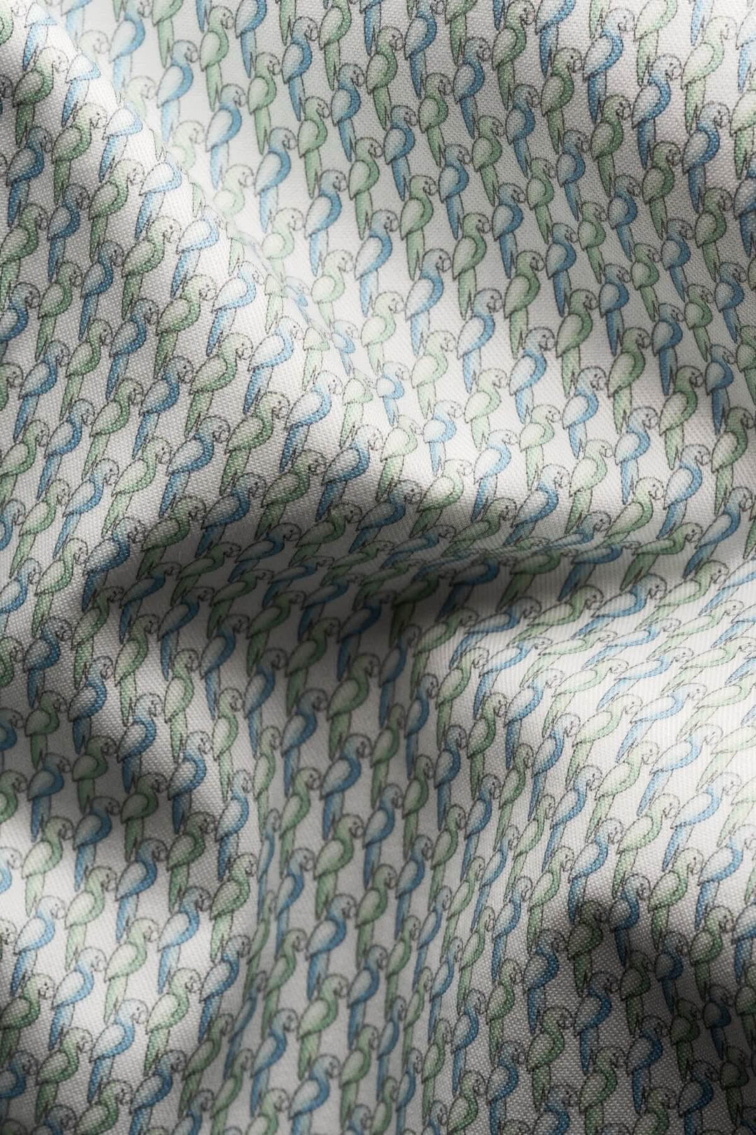 Tissu en coton avec imprimé perroquet en tons de vert pâle et bleu, idéal pour chemises élégantes.