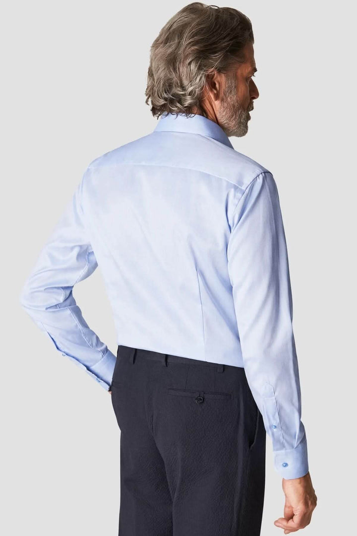 Homme portant une chemise en coton signature à col italien, vue de dos, élégance intemporelle au bureau ou lors d'occasions habillées.