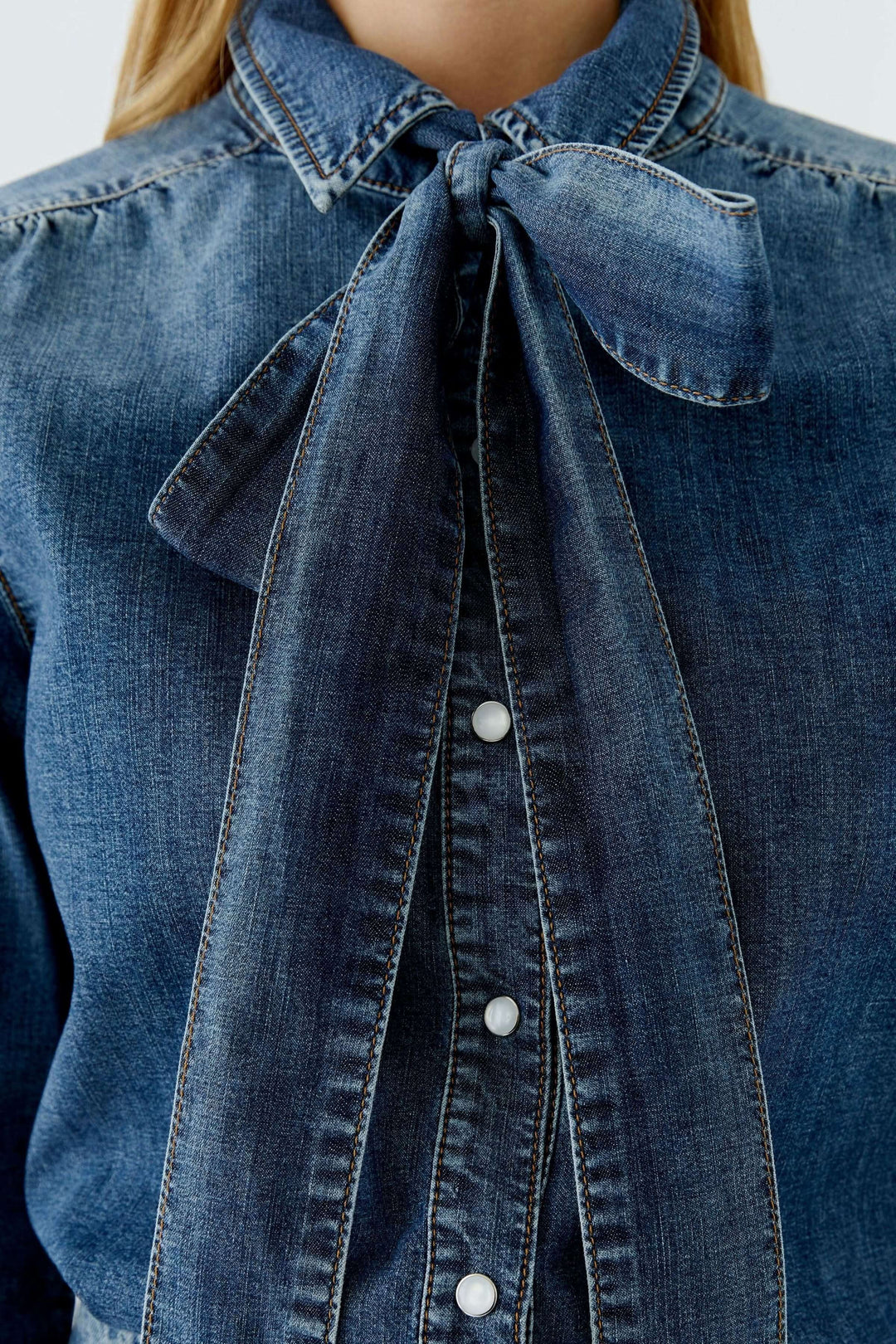 Chemise en denim avec nœud amovible en gros plan, col lavallière noué.