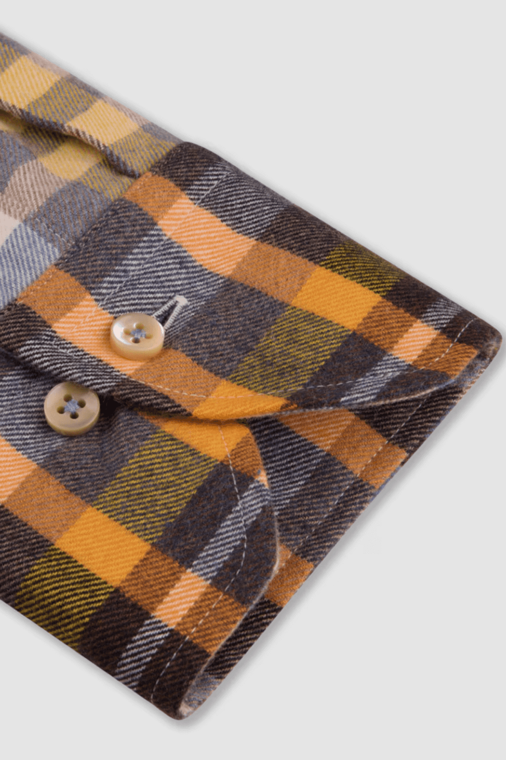 Manchette d'une chemise en flanelle à carreaux en coton, boutons en nacre et design décontracté.