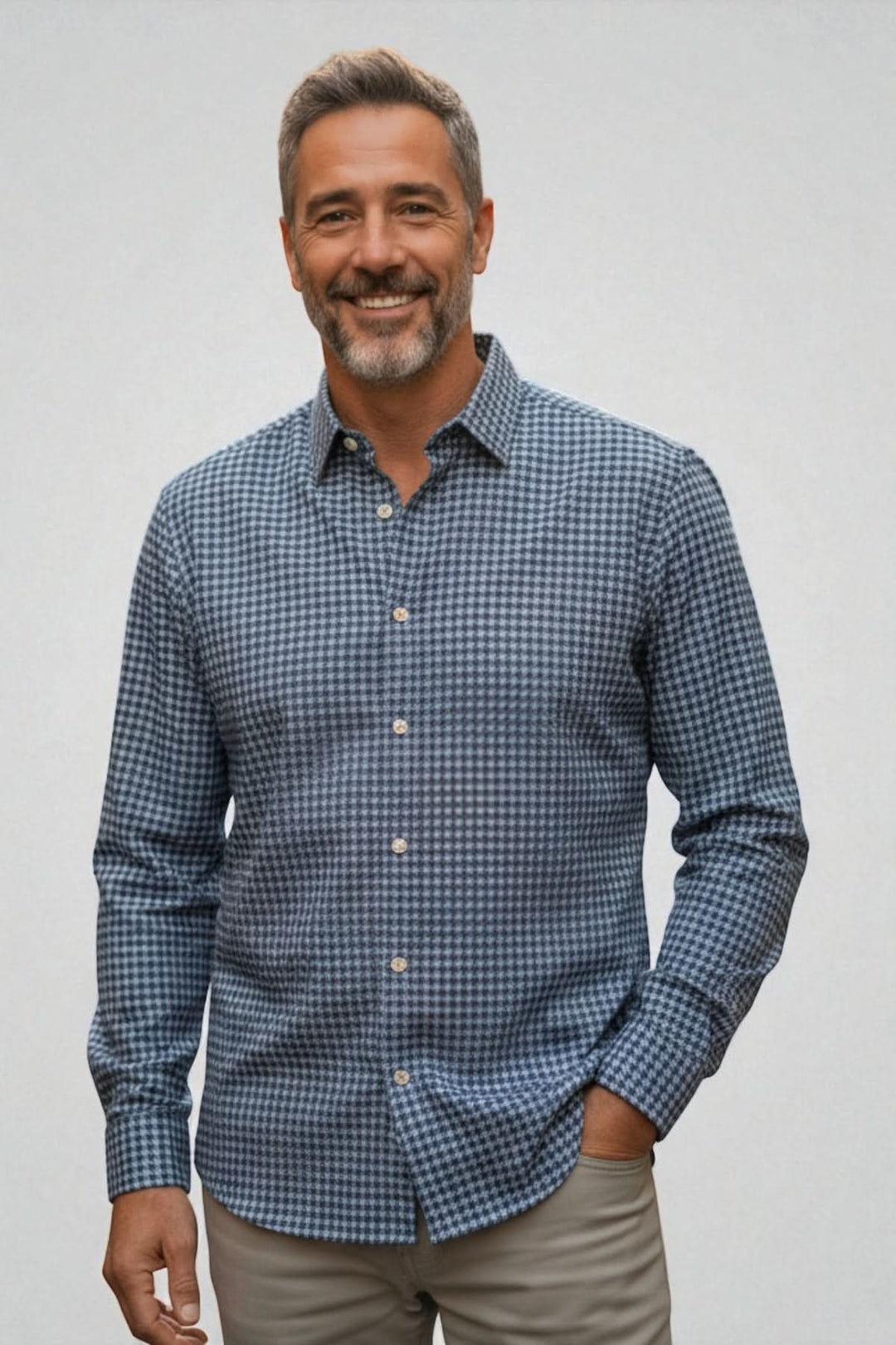 Chemise en flanelle à motif pied-de-poule avec boutons en nacre, col cut away et poignets simples, portée par un homme souriant.