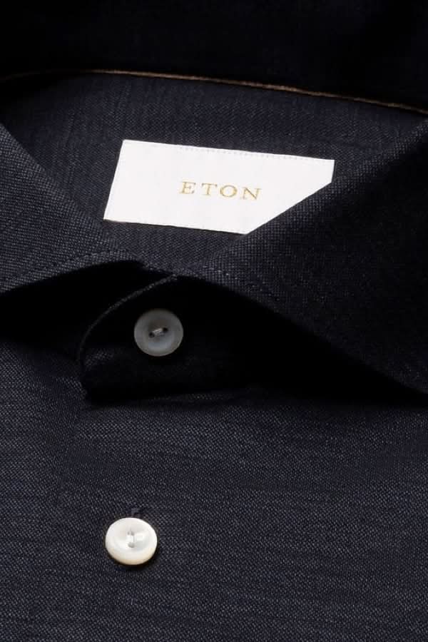 Chemise en jersey de laine mérinos avec boutons nacrés et col italien moderne. Texture douce et élégante pour un confort optimal.