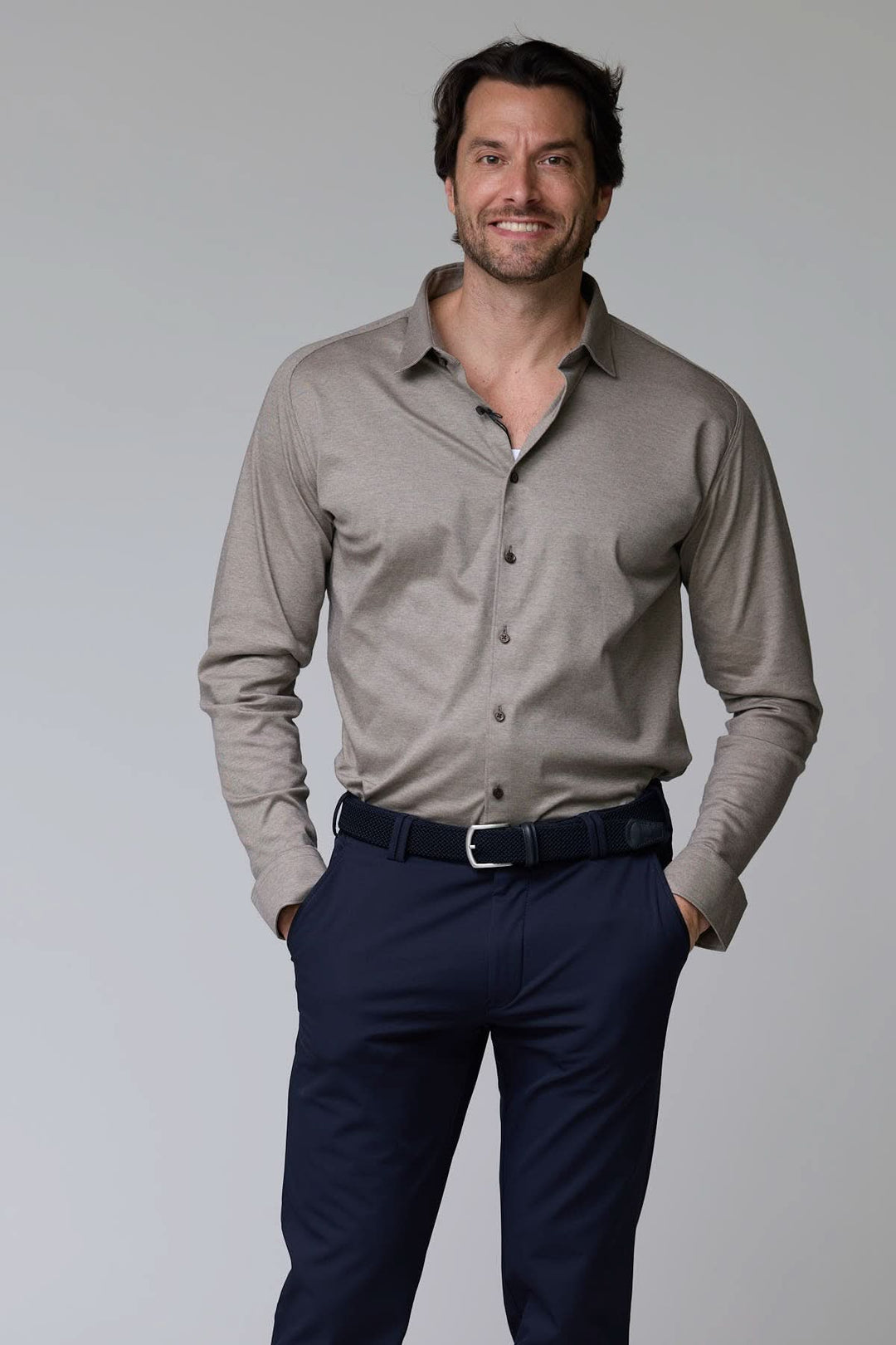 Homme portant une chemise en jersey extensible beige avec un col rigide, combinant style classique et confort moderne.
