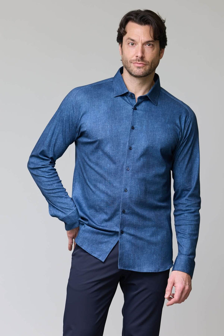 Homme portant une chemise en jersey extensible à manches longues, coupe ajustée et col classique, parfaite pour le travail et les loisirs.