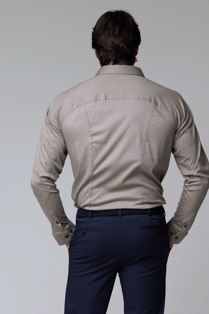 Homme portant une chemise en jersey extensible beige dos, manches longues, coupe ajustée, col structuré pour un style raffiné et confortable.