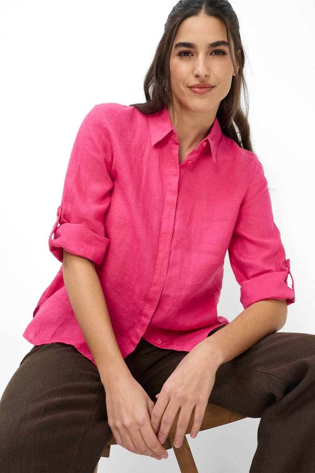 Femme portant une chemise en lin VICKI rose, à manches trois-quarts et poignets à deux boutons, pour un look moderne et élégant.