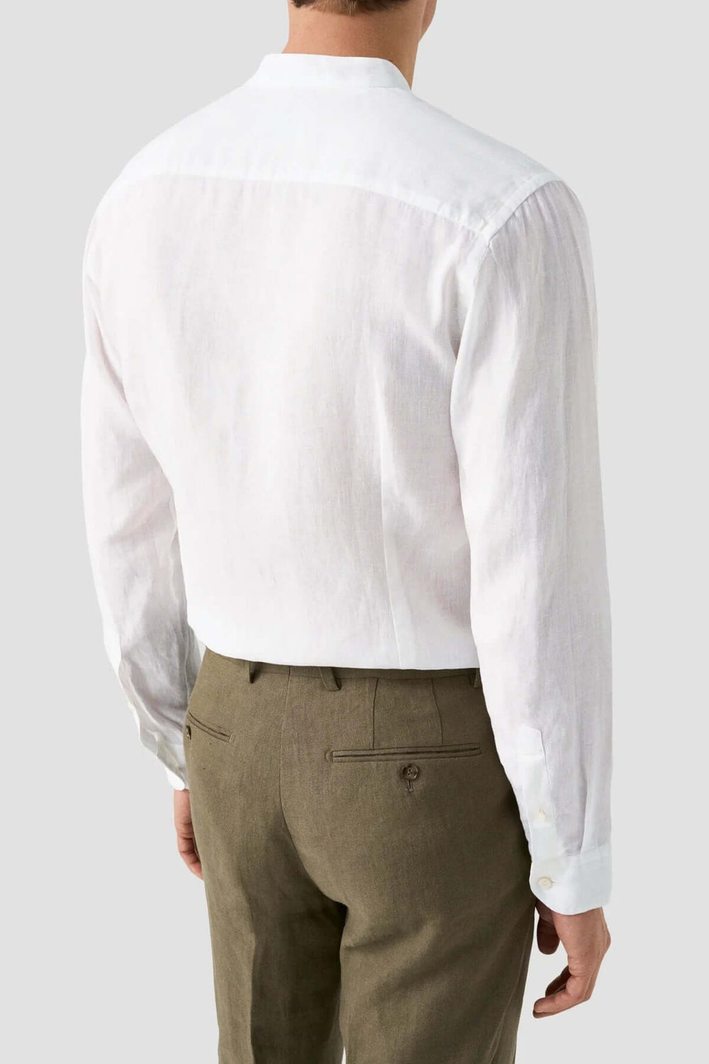 Chemise en lin blanche à col officier, vue de dos, avec pantalon kaki, pour un style décontracté et élégant.
