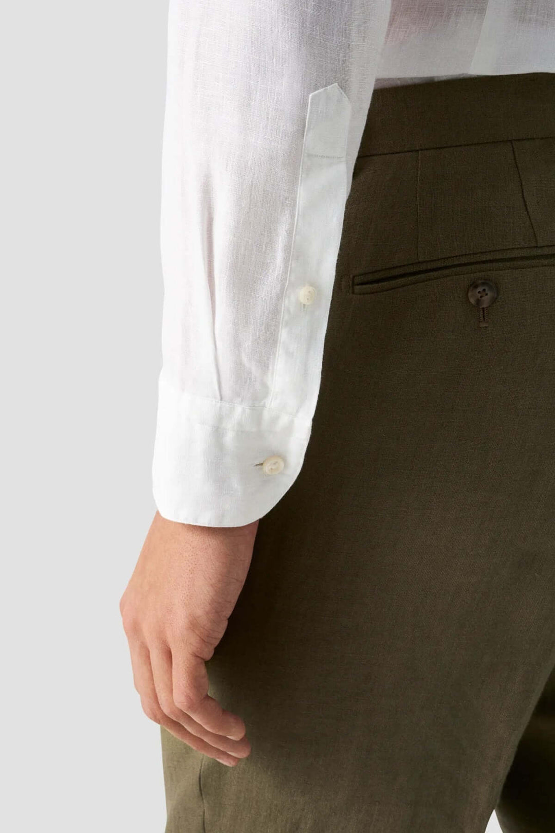 Détail de la manche d'une chemise en lin à col officier, matériau léger et texture raffinée.