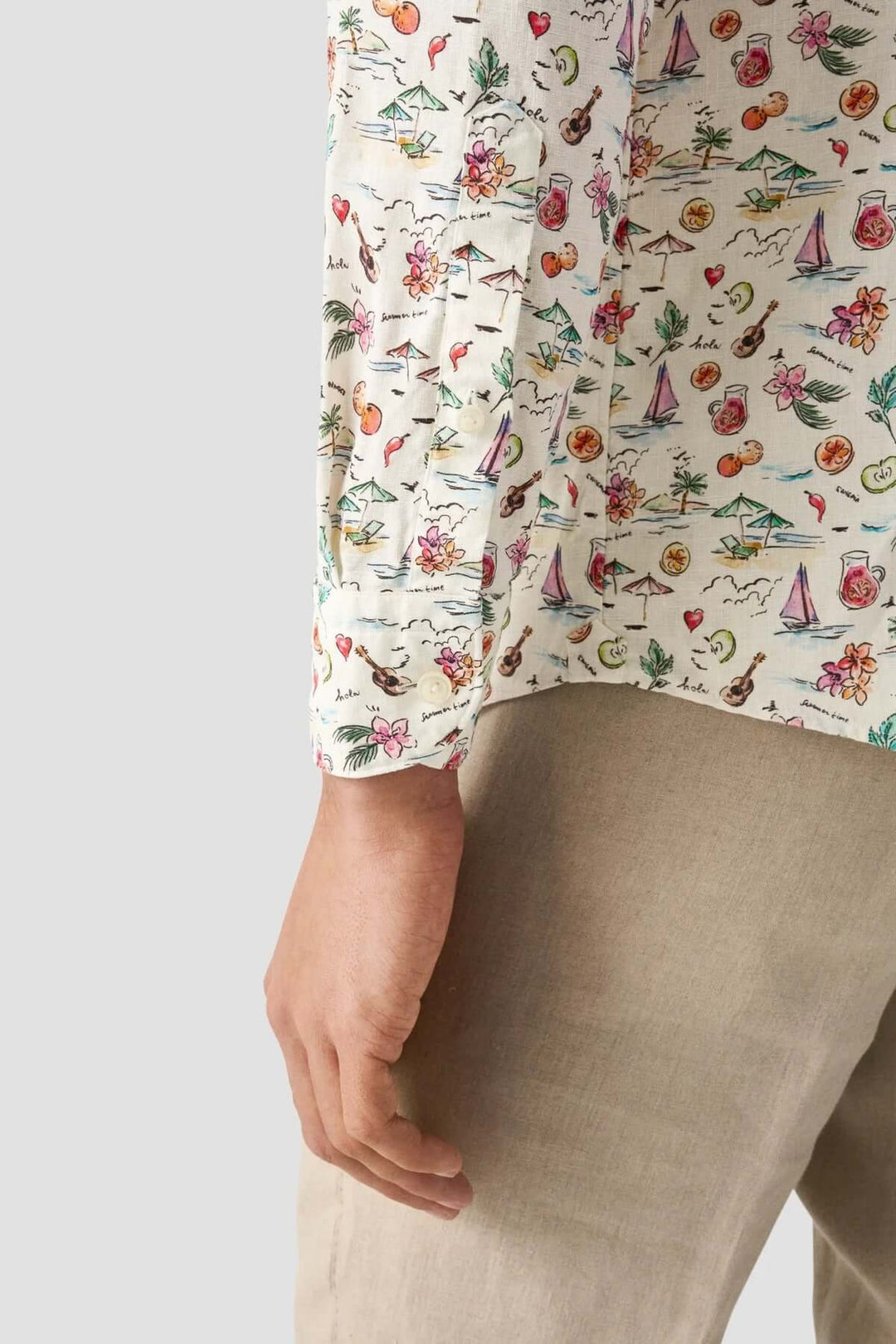 Chemise en lin avec imprimé coloré de scènes estivales, montrant la manche d'un homme.