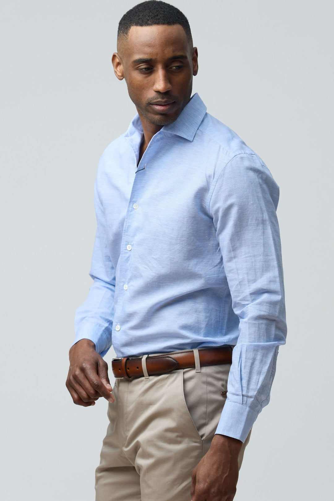 Homme portant une chemise en lin légère et raffinée, manches longues, coupe ajustée, idéale pour une tenue élégante et décontractée.