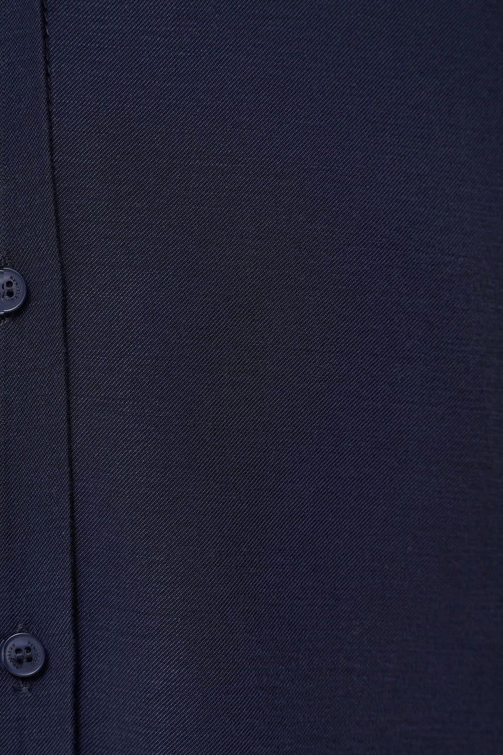 Détail d'une chemise fluide en tissu navy, avec boutons et texture élégante, alliant confort et style.