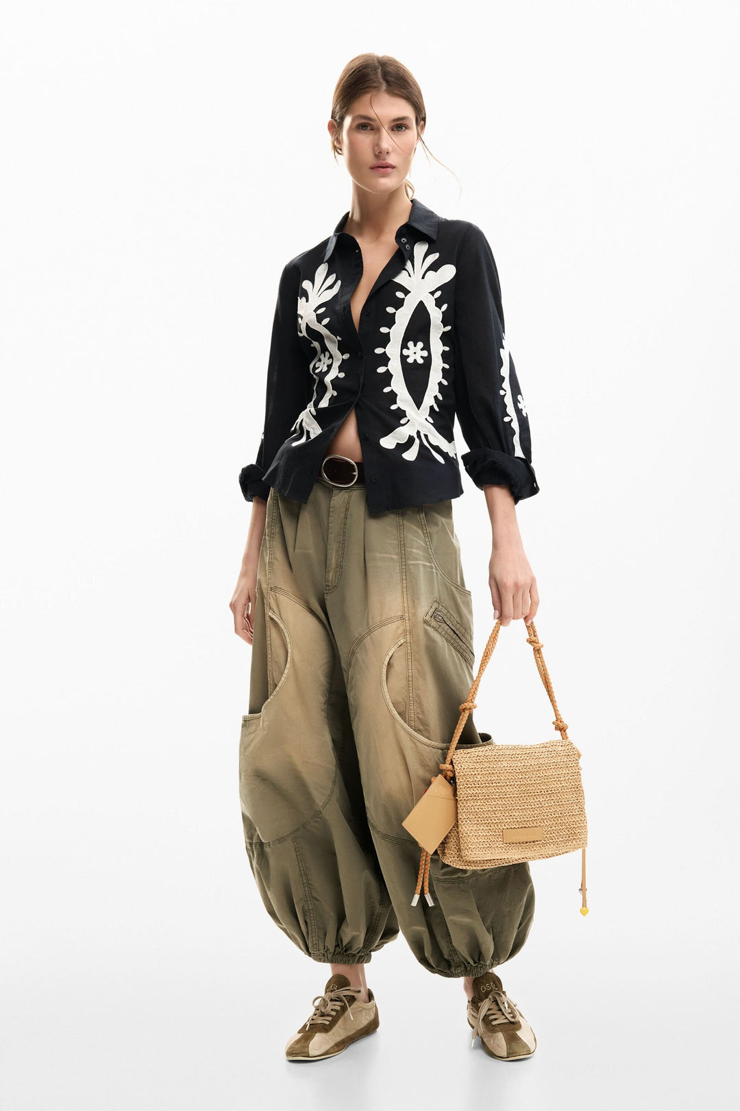 Femme portant une chemise fluide à broderies contrastées avec un pantalon ample, tenue élégante et décontractée pour le quotidien.
