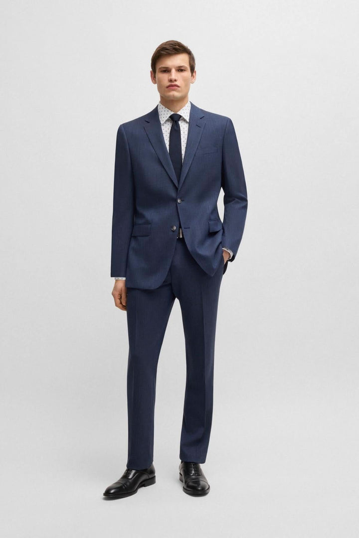 Homme en costume marine avec chemise à motif, look d'affaires élégant et moderne.