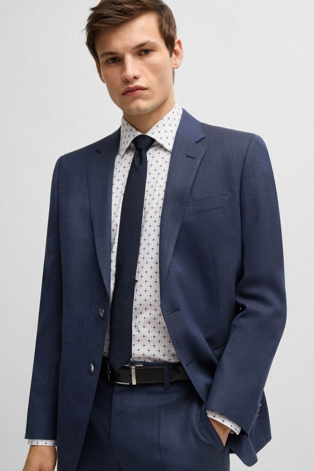 Homme en costume marine avec une chemise à motif contemporain, élégant et moderne pour un look d'affaires.