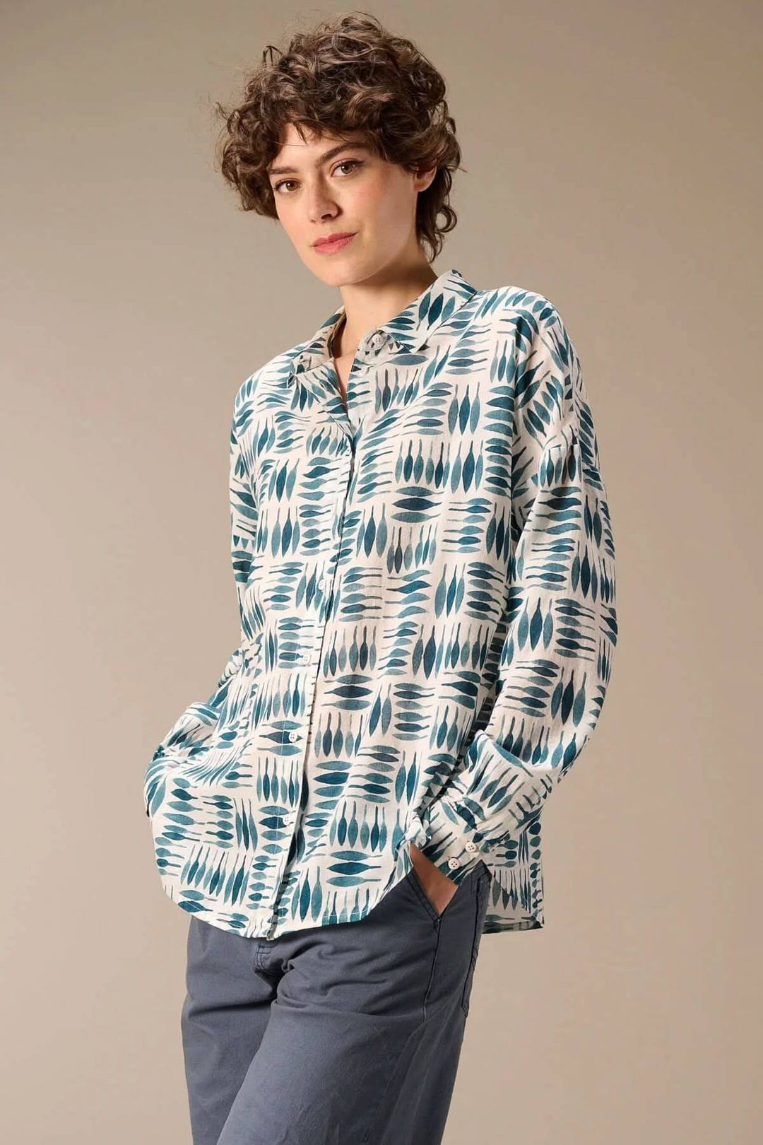 Femme portant une chemise imprimée à manches longues avec imprimé graphique, col classique, et fermeture boutonnée pleine longueur.