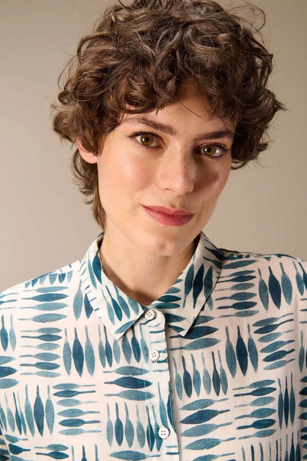 Personne portant une chemise imprimée à manches longues avec un motif graphique élégant et moderne. Vêtement léger et confortable.