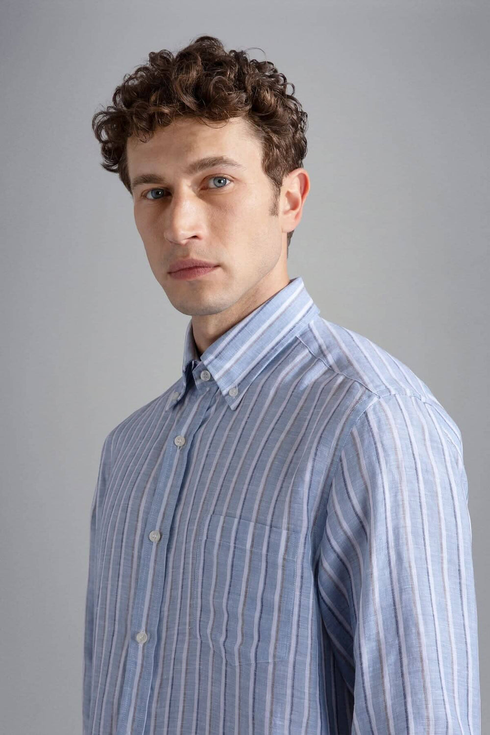 Homme portant une chemise lignée élégante en lin italien, mettant en valeur une texture raffinée et un style décontracté.