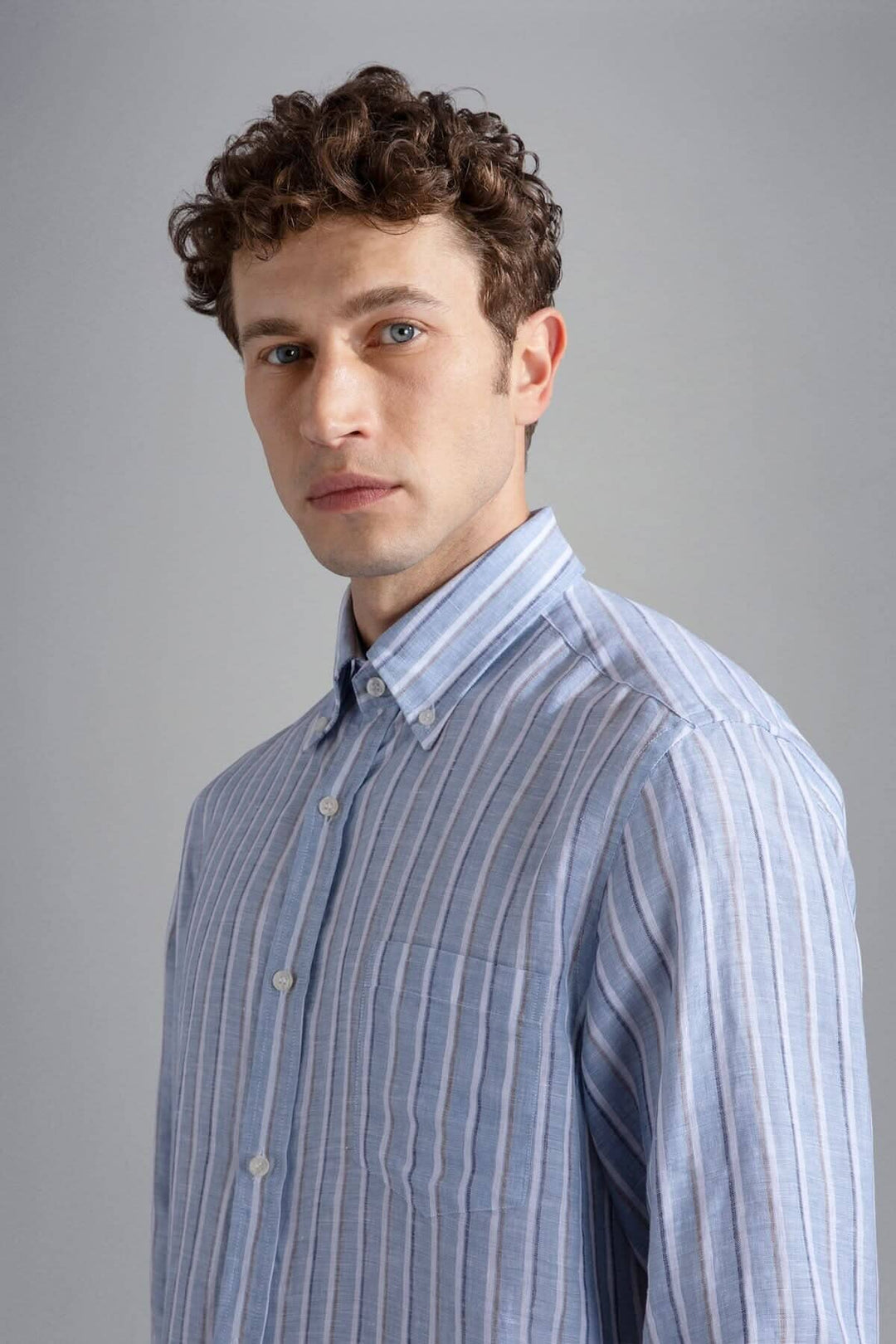 Homme portant une chemise lignée élégante en lin italien, mettant en valeur une texture raffinée et un style décontracté.