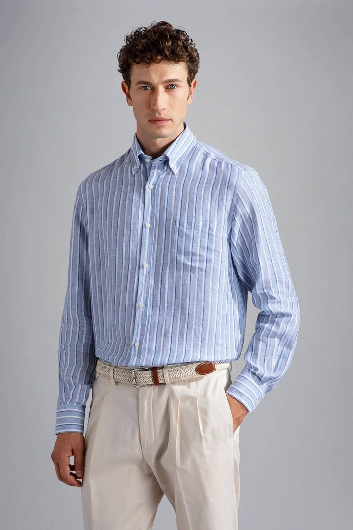 Chemise en lin à rayures bleues, élégante et décontractée, portée avec un pantalon clair.