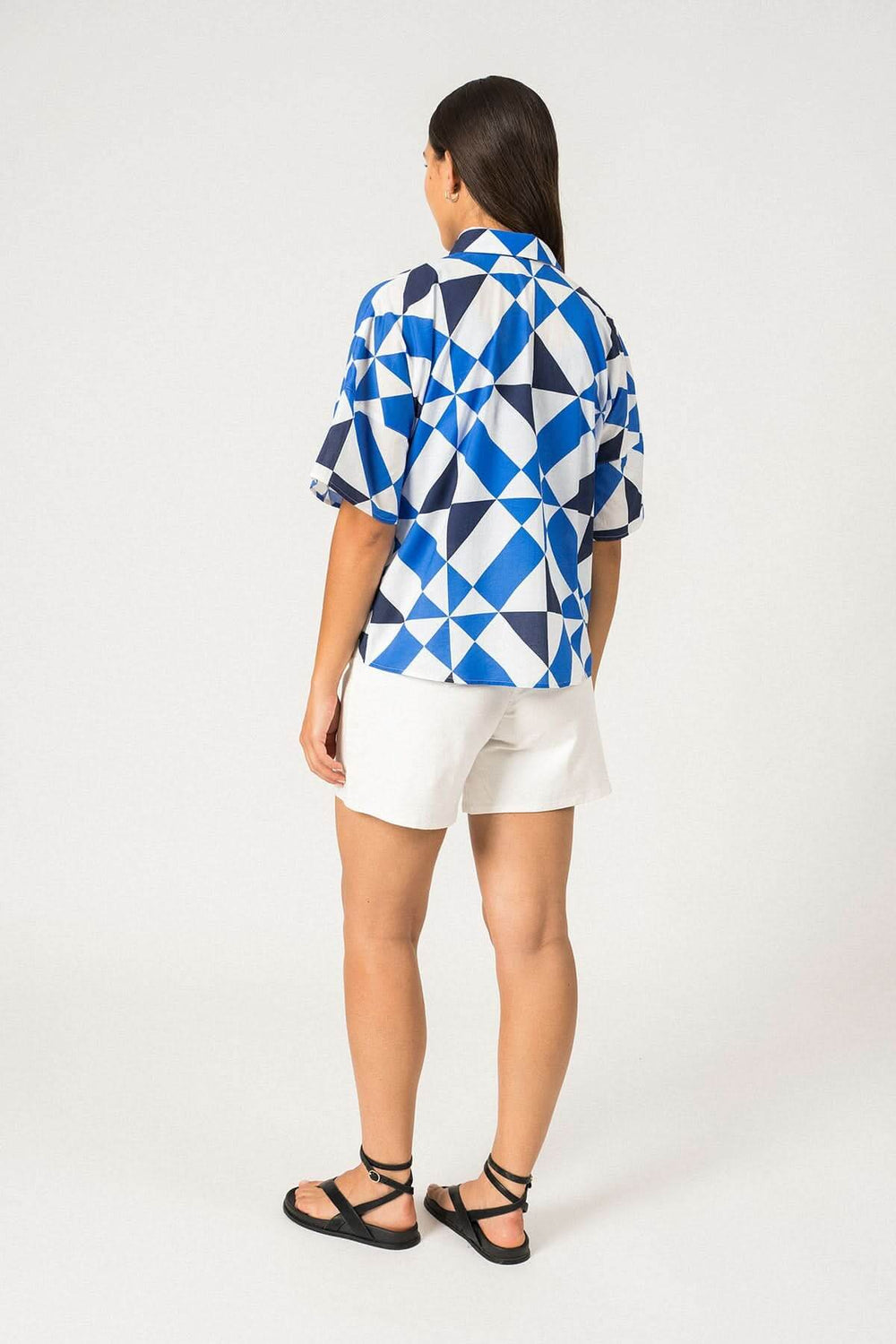 Chemise géométrique bleue à manches courtes, vue arrière sur modèle. Parfaite pour l'été, style oversize.