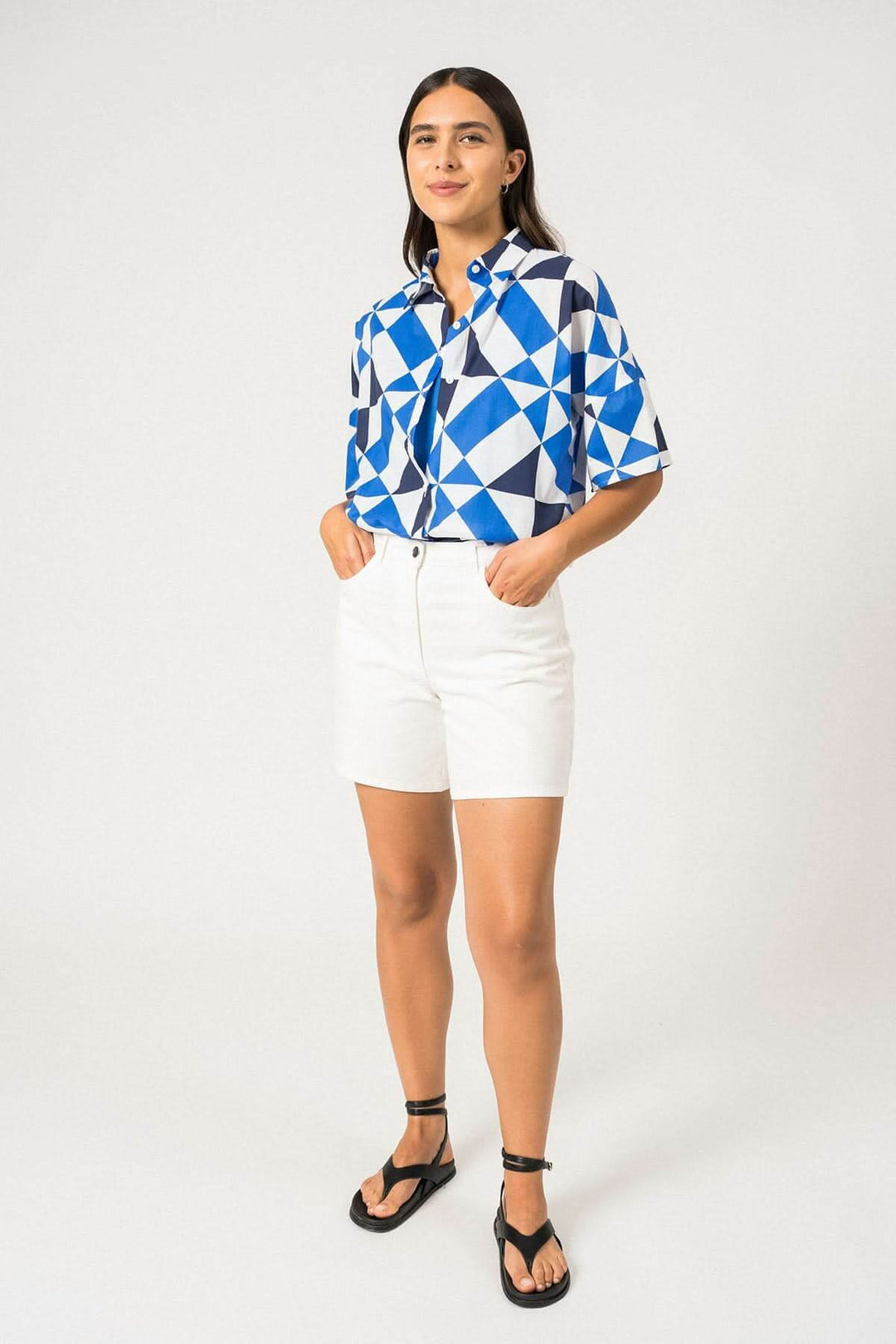 Chemise manches courtes LUCIE à motifs géométriques en bleu, portée avec un short blanc.