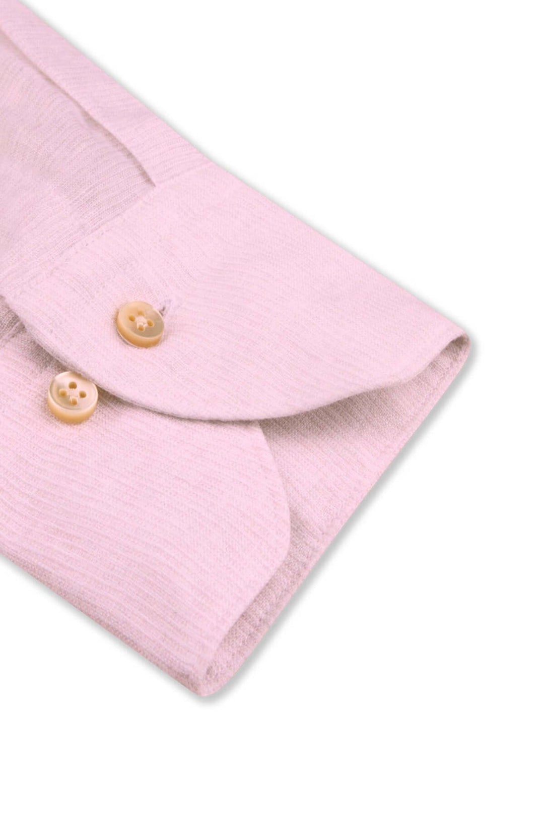 Détail d'une chemise à manches longues en lin avec col classique et boutons en nacre, coloris doux.