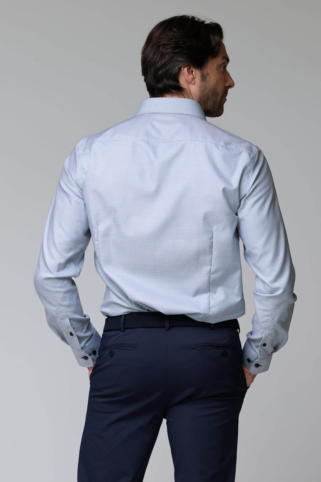 Homme portant une chemise à micro-motif texturé, coupe ajustée, vue de dos, idéale pour occasions chics ou bureau.