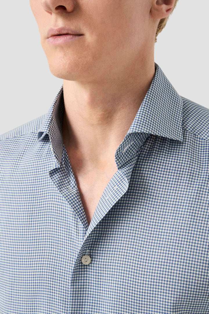 Chemise habillée à motif carreaux fins, col classique ouvert et coupe ajustée pour un look moderne.