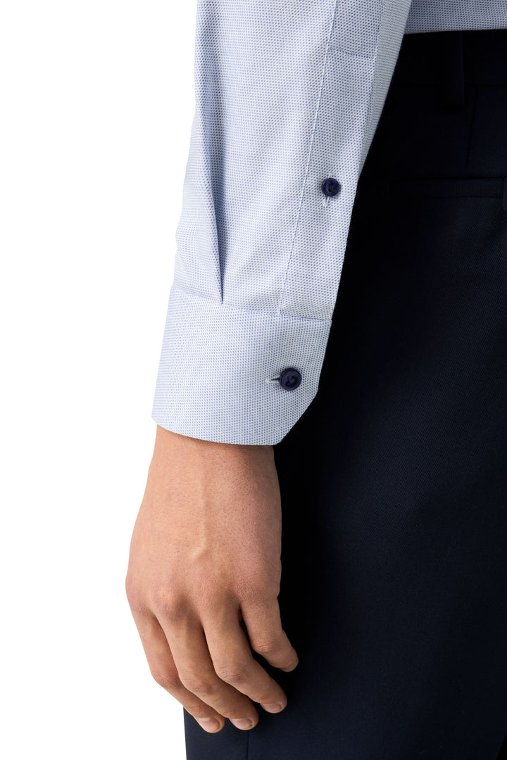 Man's fitted shirt sleeve with discreet pattern and classic cuff detail, showcasing modern elegance.