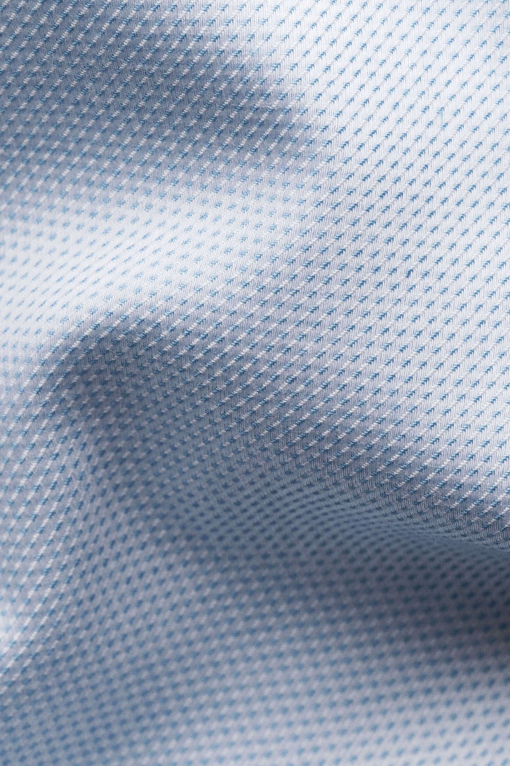 Tissu de chemise bleu clair avec motif discret, doux au toucher, parfait pour une élégance moderne.