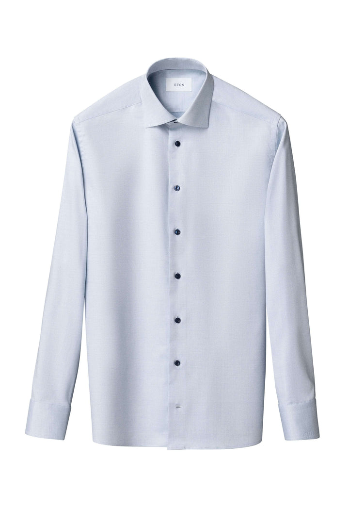 Chemise à motif discret bleu clair avec col ouvert et boutons, pour élégance moderne en toutes occasions.