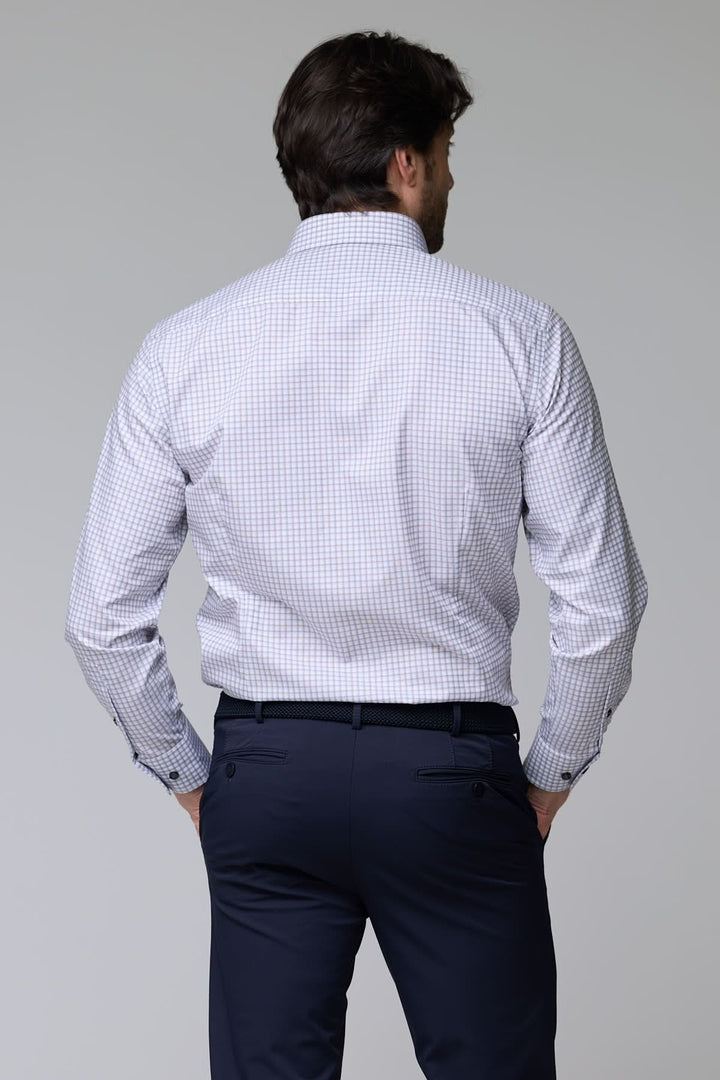 Homme portant une chemise à motif discret avec manches longues et coupe ajustée moderne.