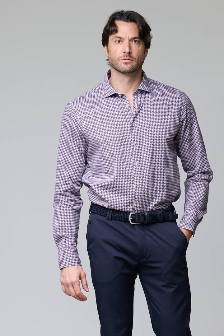 Homme portant une chemise à motif géométrique ajustée, manches longues, idéale pour tenues professionnelles élégantes et modernes.