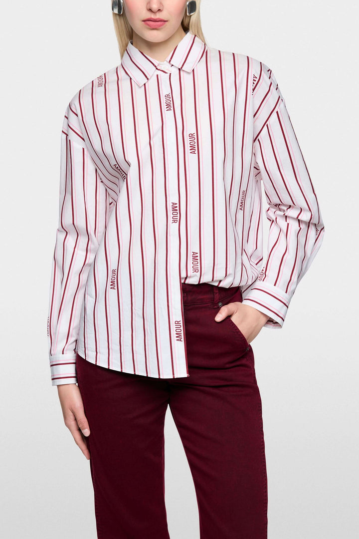 Chemise rayée en coton biologique avec boutons cachés et manches longues, label Rethink Together, portée par un mannequin.