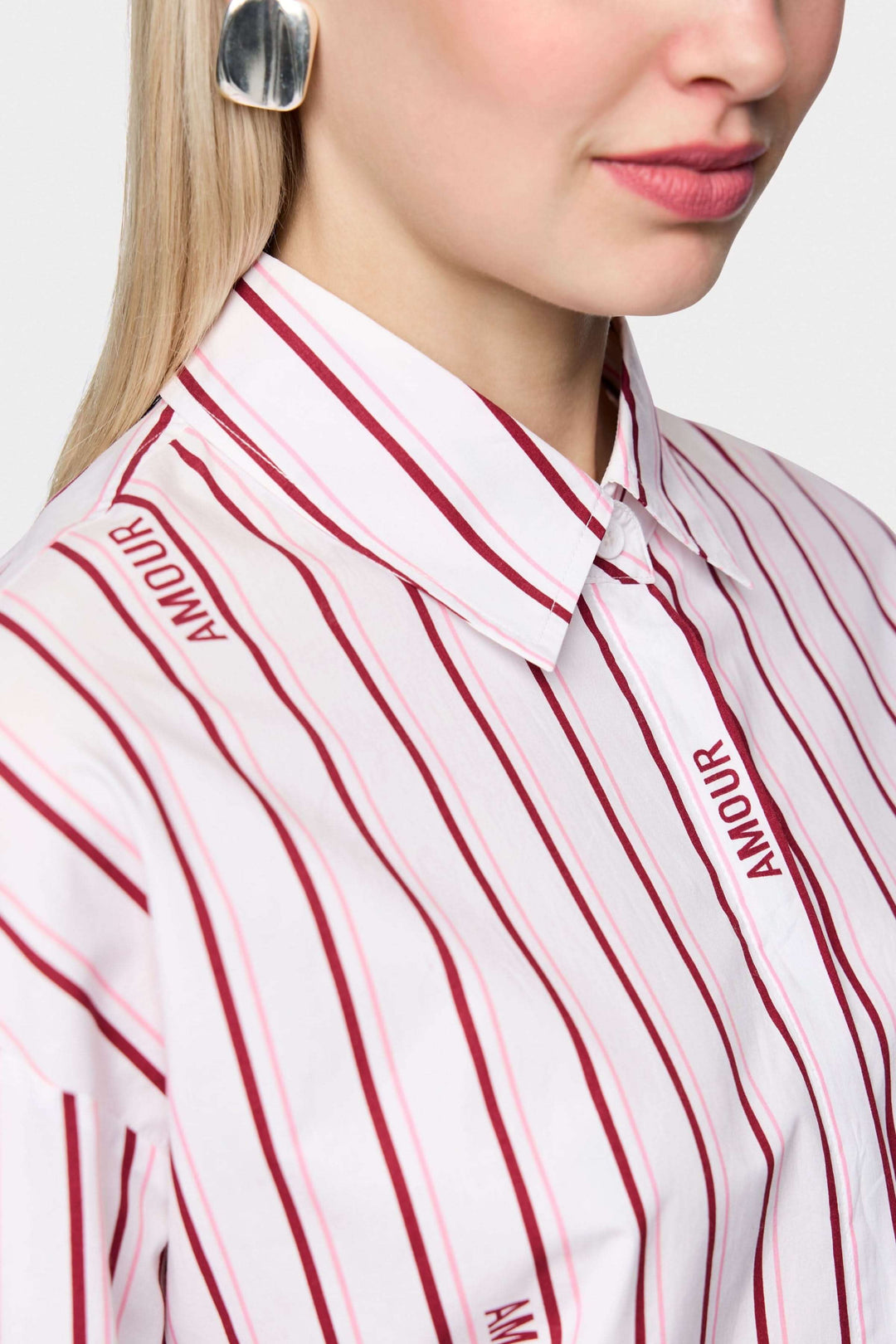 Chemise rayée en coton biologique avec rayures modernes et inscription "Amour", détail du col et de la manche