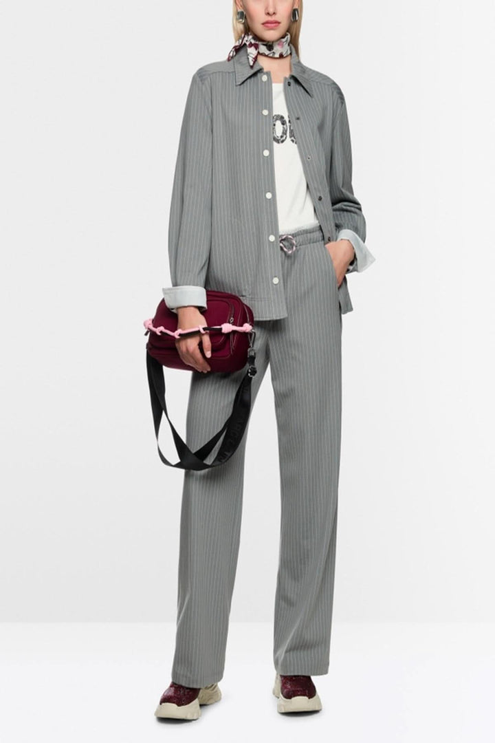 Chemise rayée décontractée avec motif rayé, poches latérales et élastique à la taille, portée avec pantalon assorti et accessoires.