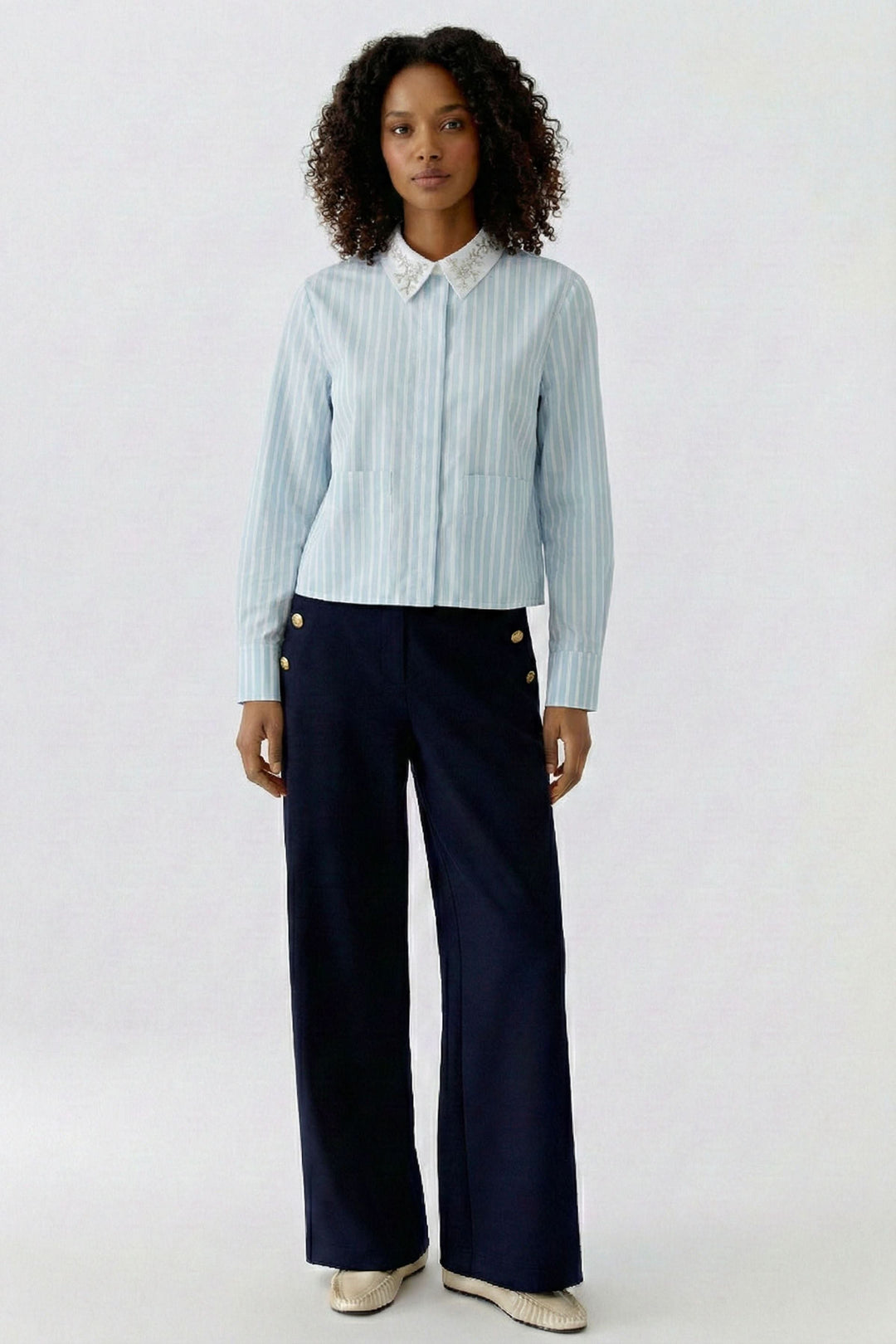 Femme portant une chemise rayée à col brodé élégante, idéale pour le bureau et les occasions habillées.