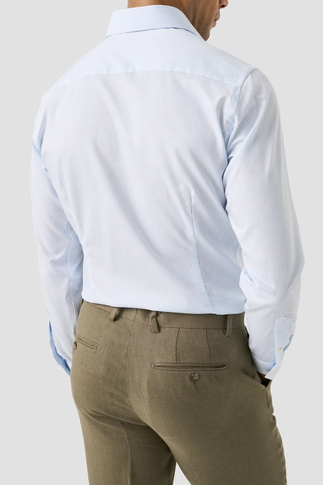Homme portant une chemise rayée en coton et lyocell, élégante et légère, vue de dos avec col italien et rayures fines.