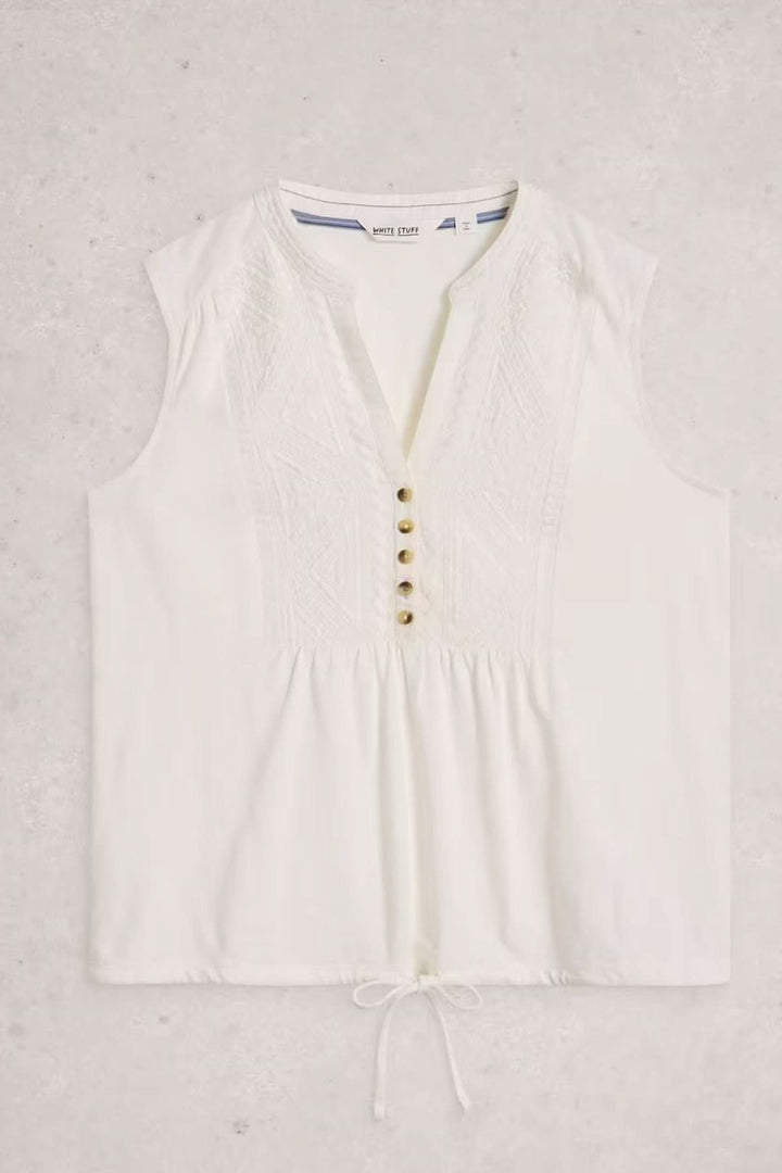 Chemise sans manches Peony avec plastron brodé, encolure ouverte, boutons décoratifs, élégante et fluide, blanche.