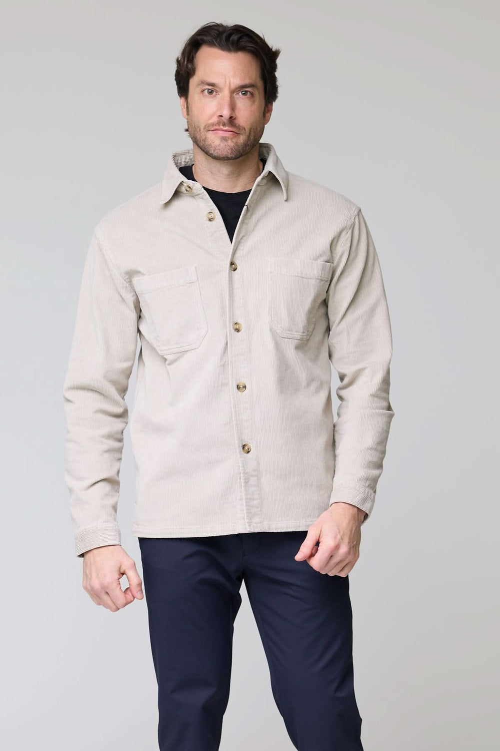 Homme portant une chemise sport en velours côtelé style surchemise avec poches plaquées, idéale pour un look décontracté et sophistiqué.