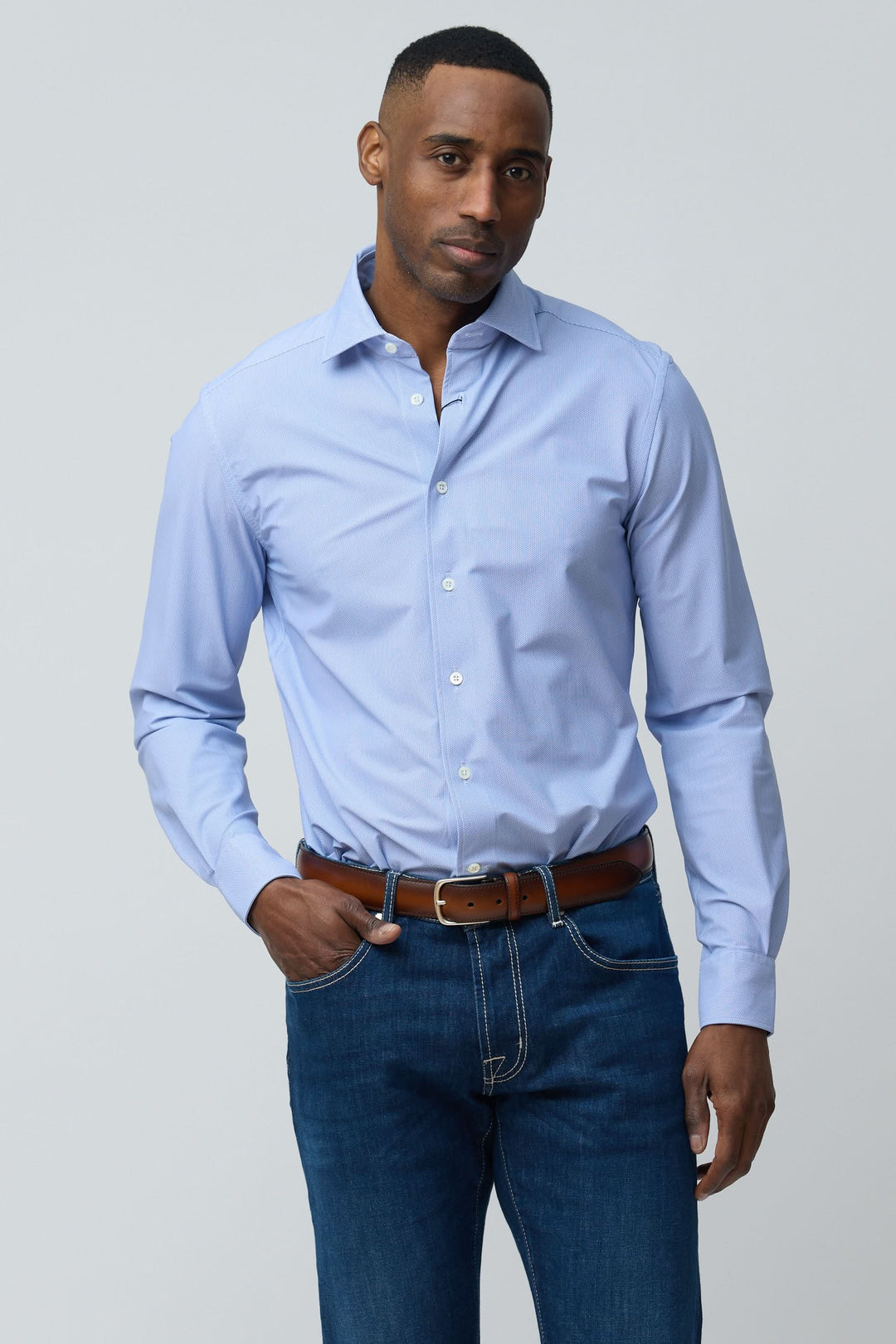 Homme portant une chemise structurée à micro-motif bleue, ajustée pour un look élégant et confortable, idéale pour le bureau ou les sorties habillées.