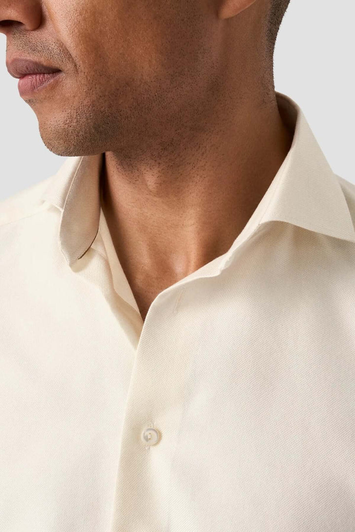 Chemise unie en coton beige avec col classique et coupe droite, parfaite pour les tenues élégantes.