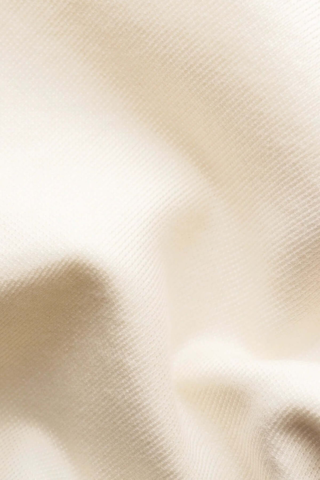 Zoom sur un tissu en coton beige doux et soyeux, idéal pour la confection de vêtements élégants.