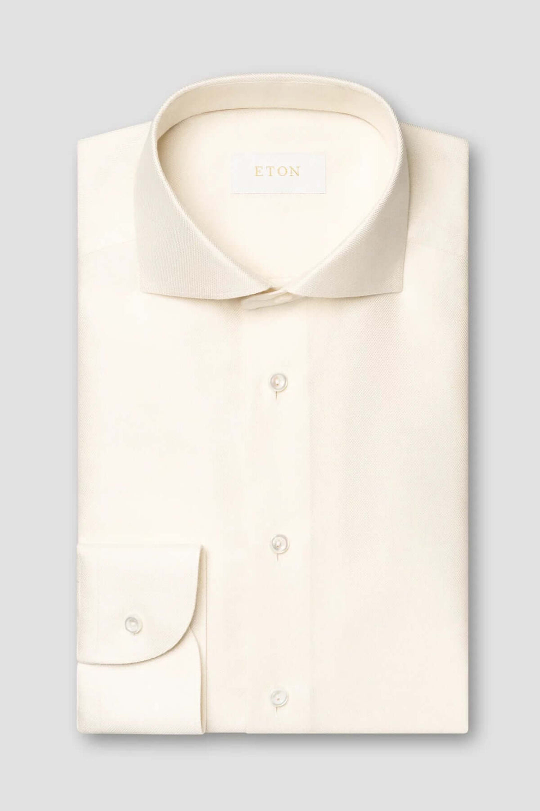 Chemise unie en coton crème avec col classique et poignets simples, élégante et raffinée.