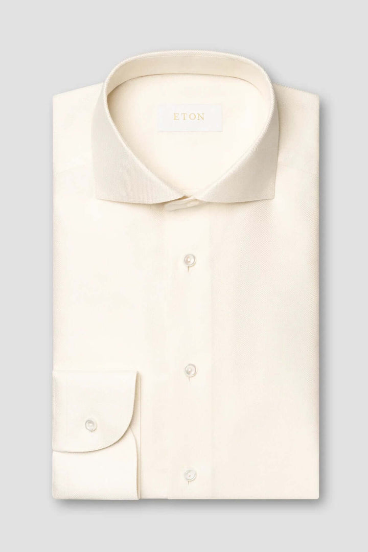 Chemise unie en coton crème avec col classique et poignets simples, élégante et raffinée.