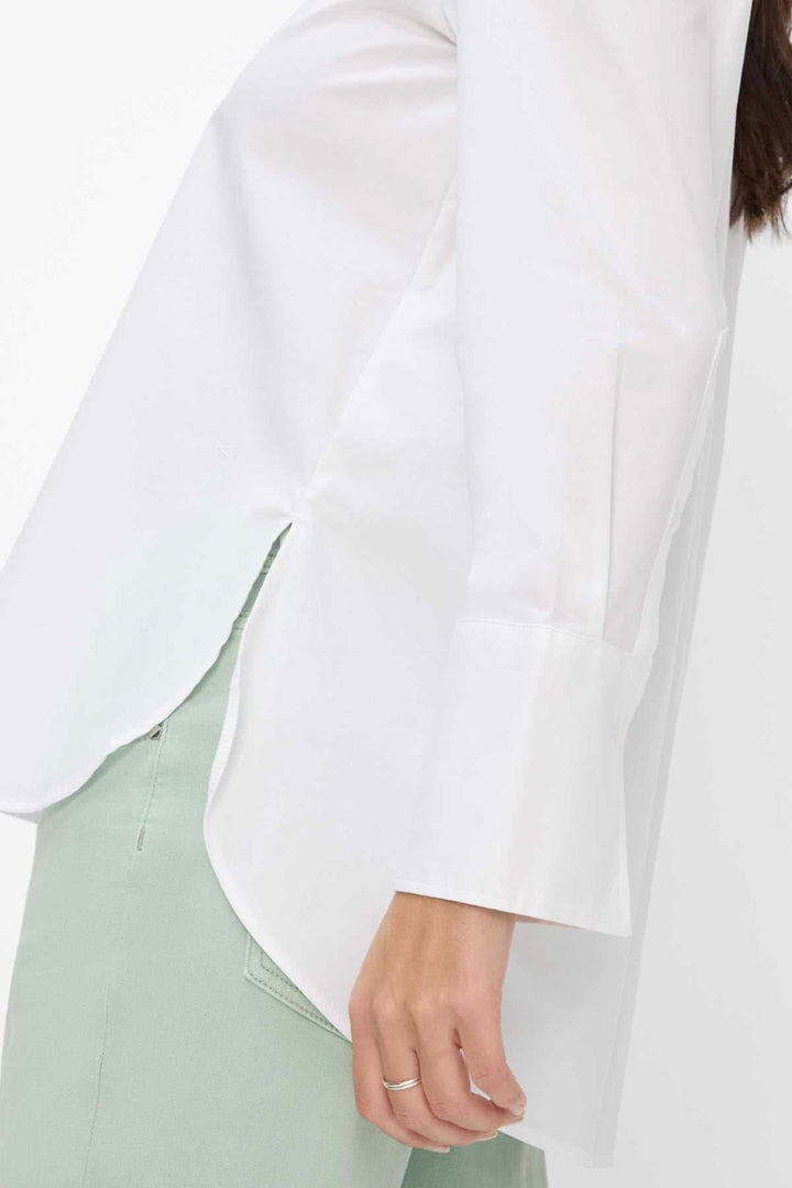 Détail du chemisier classique VIKI, manches longues, col boutonné, silhouette évasée, détails élégants.